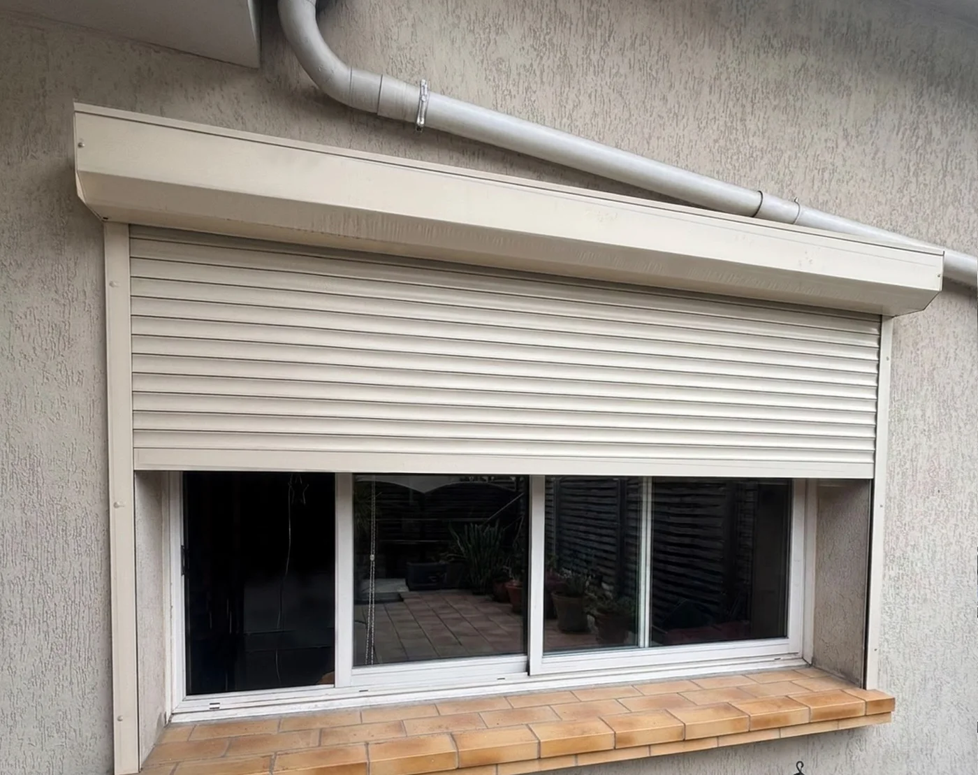 Volet rénovation beige, coffre sur la façade, mi-ouvert